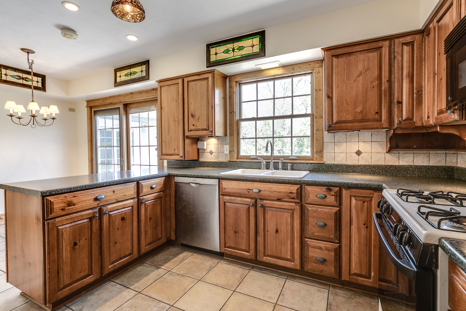 591 Surryse Road Lake Zurich, IL 60047 - Photo 12 of 33 a kitchen with stainless steel appliances granite countertop a stove a sink and a microwave