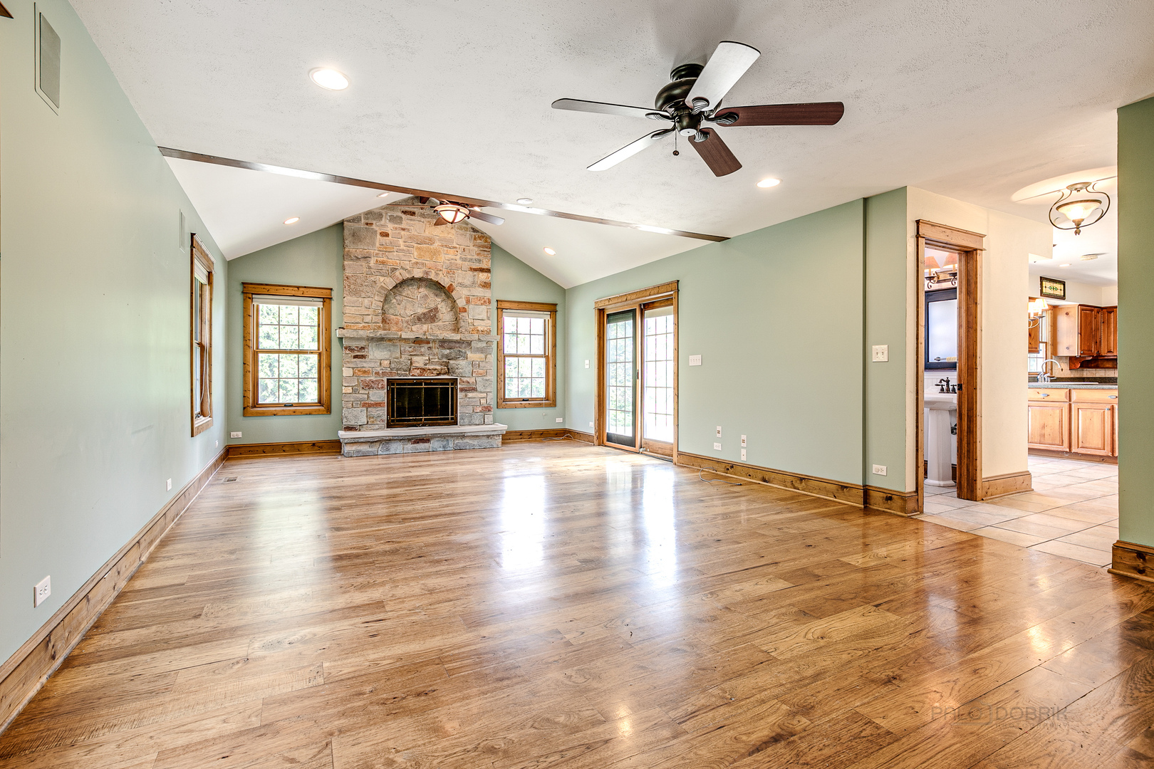 591 Surryse Road Lake Zurich, IL 60047 - Photo 13 of 33 an empty room with wooden floor chandelier fan and windows
