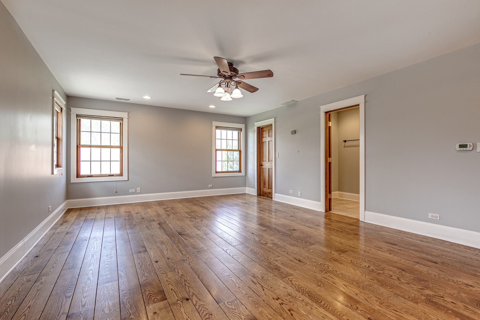 591 Surryse Road Lake Zurich, IL 60047 - Photo 19 of 33 an empty room with wooden floor ceiling fan and windows