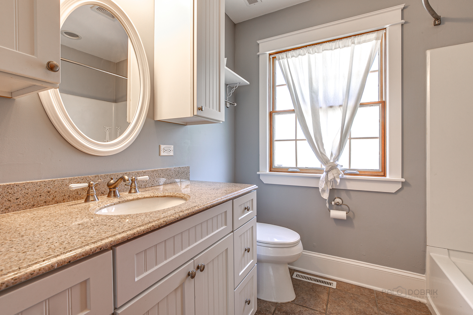 591 Surryse Road Lake Zurich, IL 60047 - Photo 26 of 33 a bathroom with a granite countertop toilet a sink and a mirror