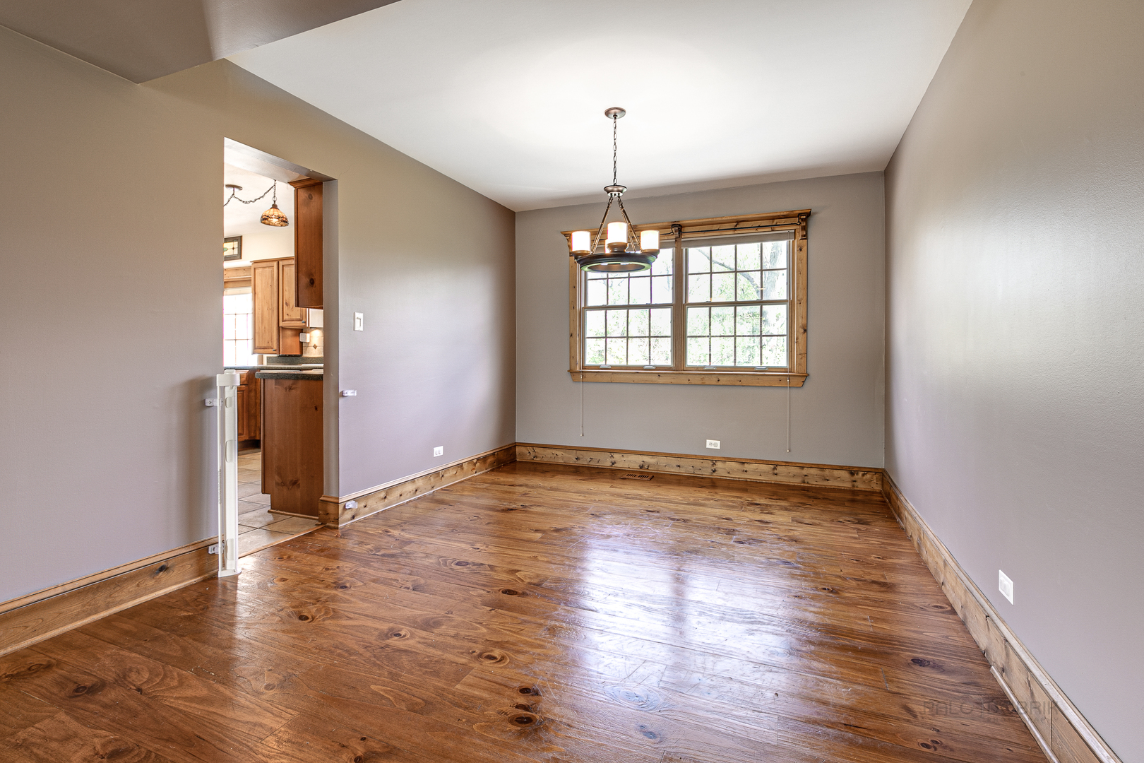 591 Surryse Road Lake Zurich, IL 60047 - Photo 8 of 33 an empty room with wooden floor chandelier and windows