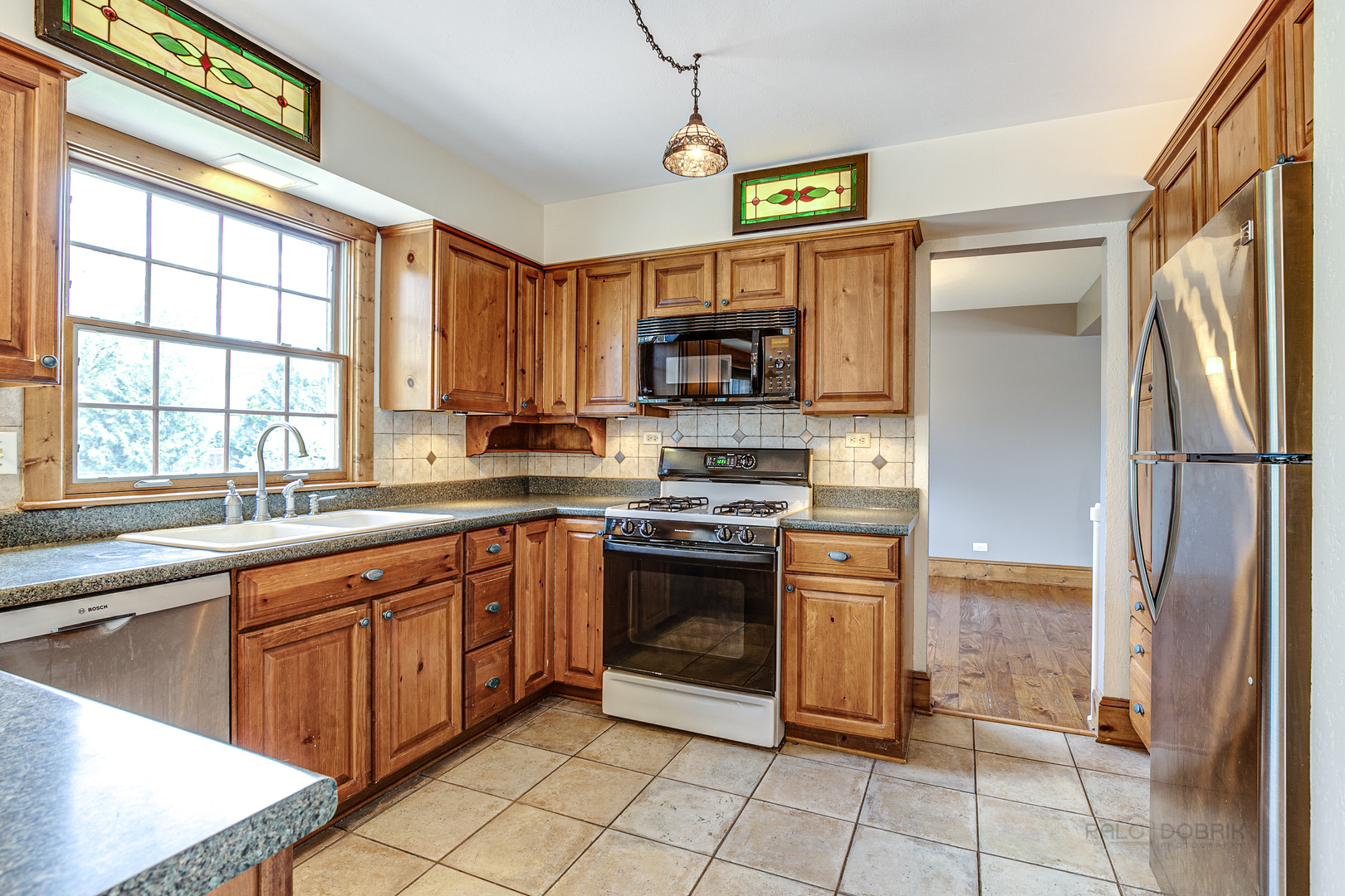 591 Surryse Road Lake Zurich, IL 60047 - Photo 10 of 33 a kitchen with stainless steel appliances granite countertop a refrigerator and a stove top oven