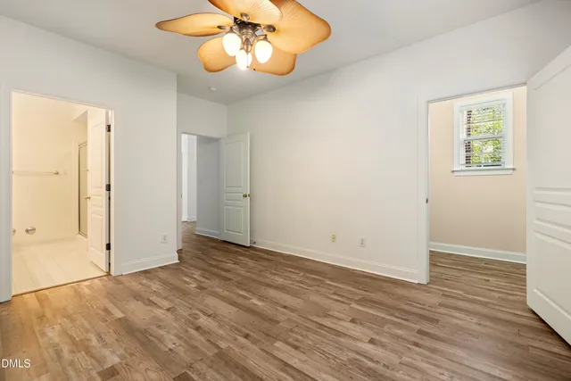 an empty room with wooden floor and chandelier fan