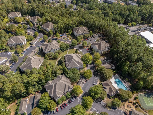 an aerial view of residential house with outdoor space and trees all around