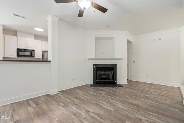 a view of empty room with wooden floor and fireplace