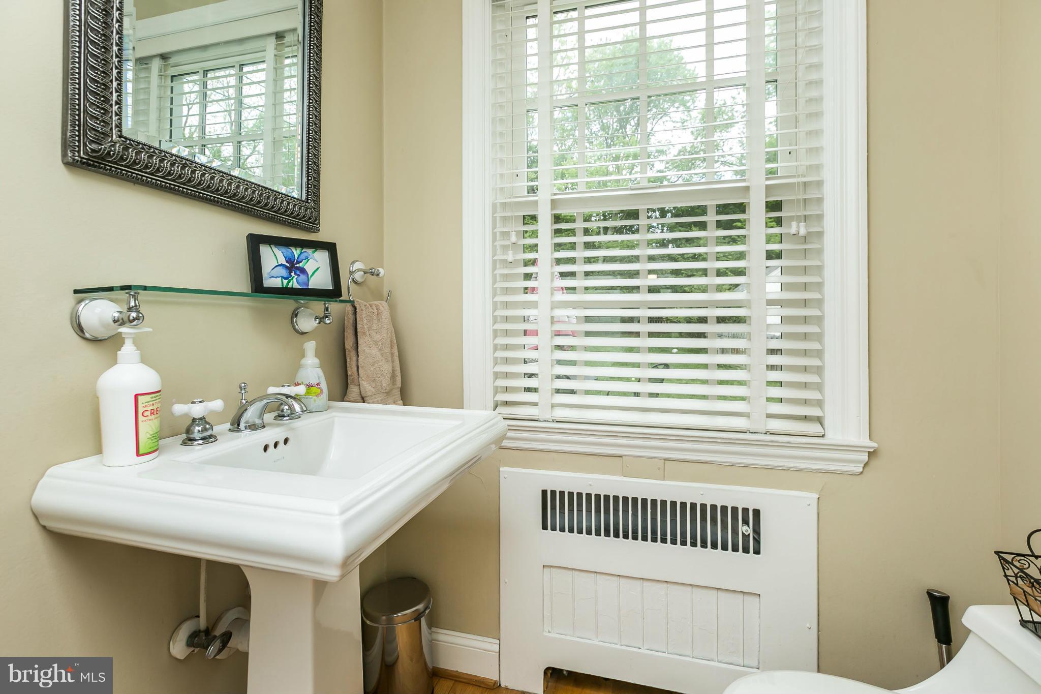 5716 Kenmore Road Baltimore, MD 21210 - Photo 12 of 30 a bathroom with a sink and a mirror