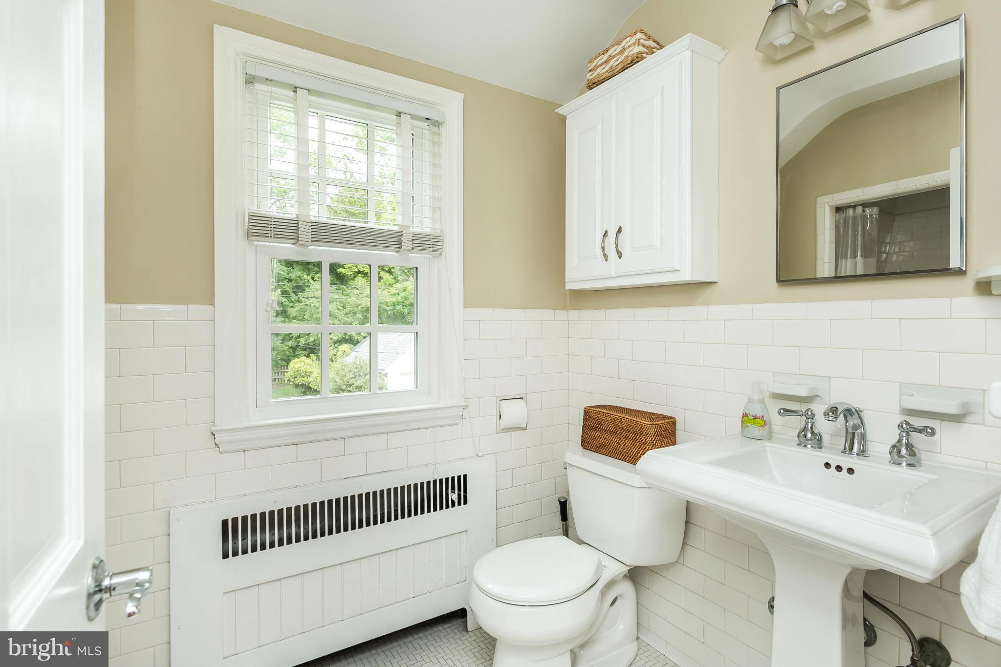 5716 Kenmore Road Baltimore, MD 21210 - Photo 15 of 30 a bathroom with a sink toilet a mirror and next to a window