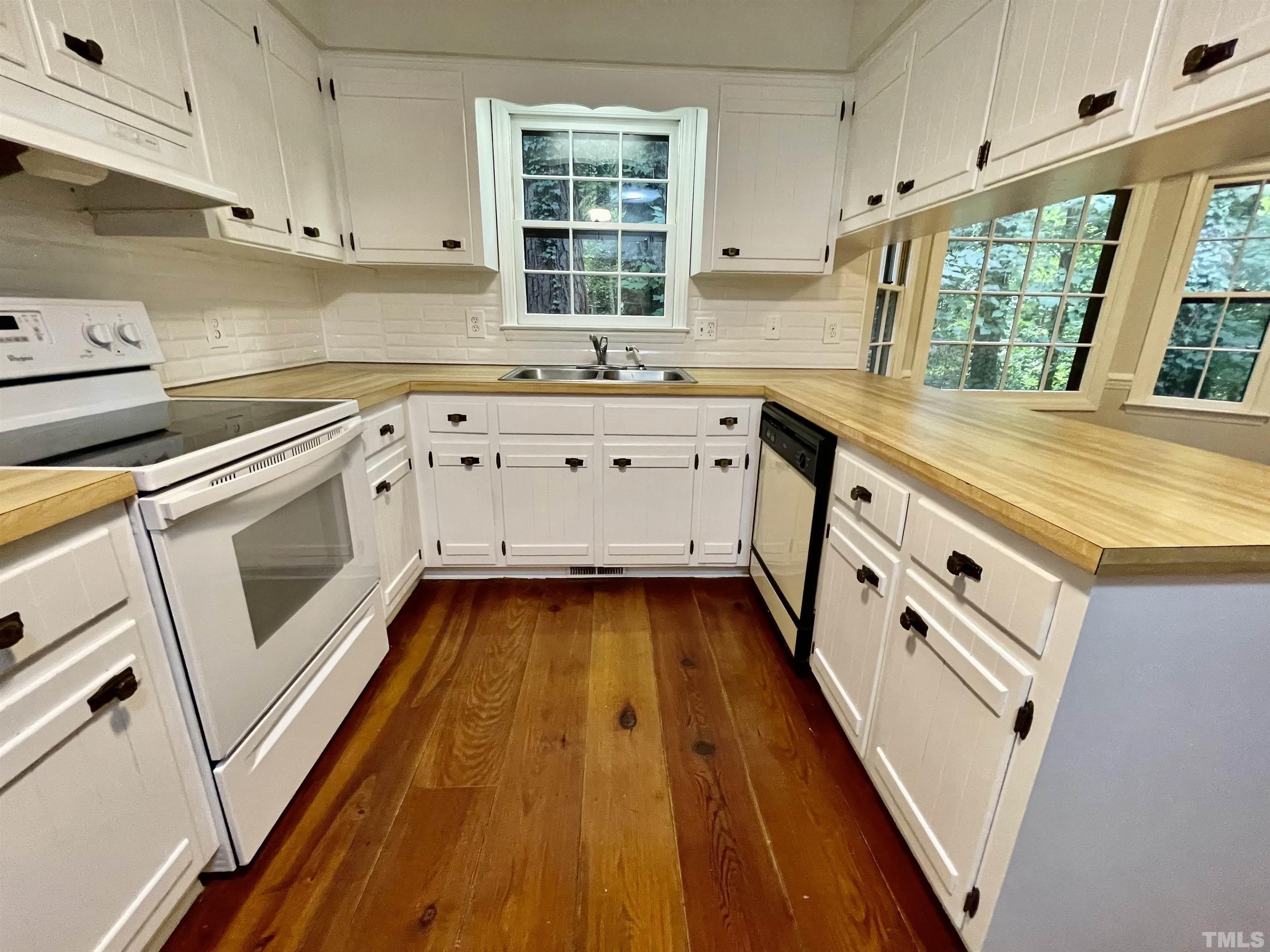3100 Shadwell Court Raleigh, NC 27613 - Photo 11 of 30 a kitchen with stove cabinets and wooden floor