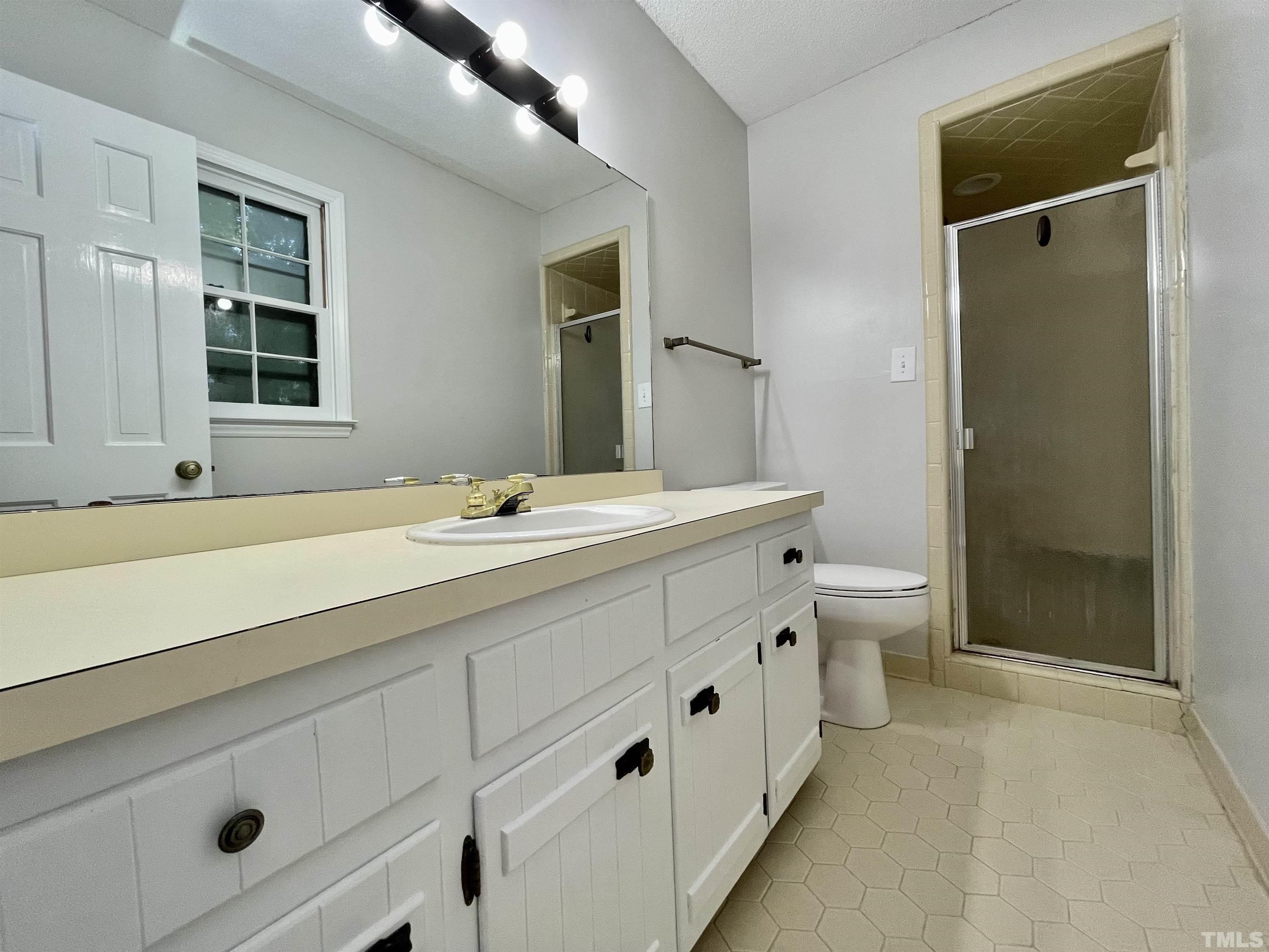 3100 Shadwell Court Raleigh, NC 27613 - Photo 23 of 30 a bathroom with double vanity sink a mirror and a bathtub