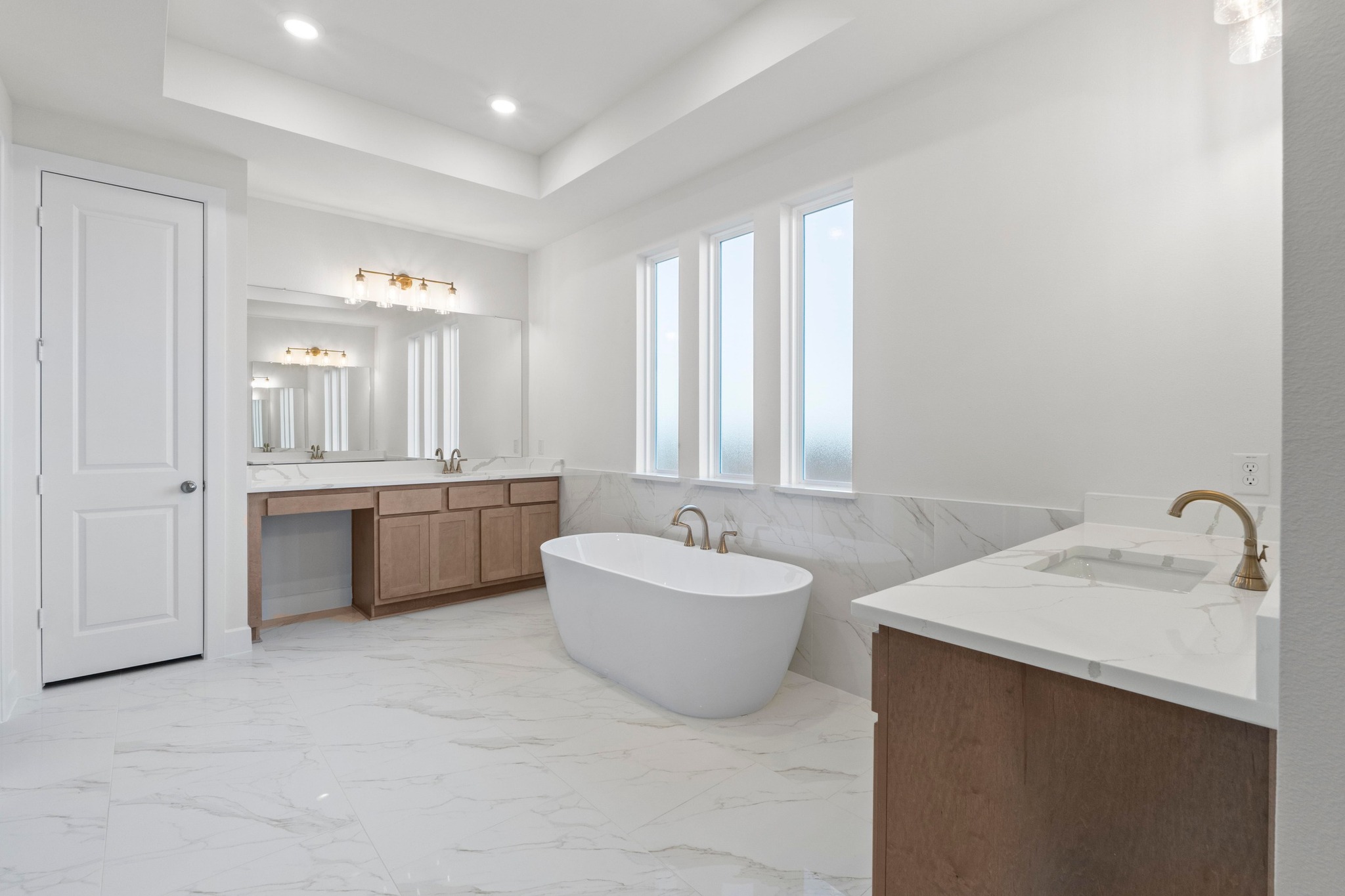 604 Lightstone Drive Georgetown, TX 78633 - Photo 15 of 39 a bathroom with a double vanity sink a mirror and a bathtub