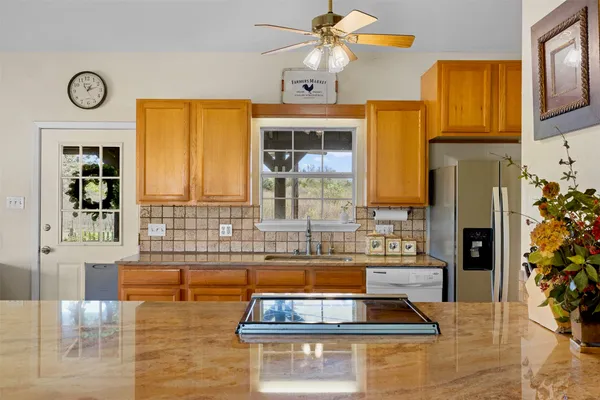 a kitchen with stainless steel appliances kitchen island granite countertop a sink and cabinets