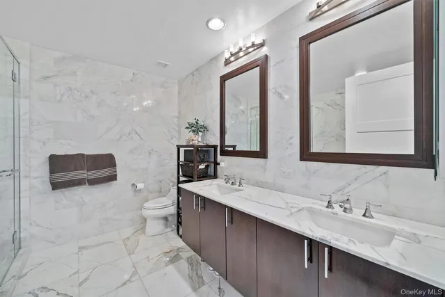 a bathroom with a double vanity sink a mirror and a bathtub