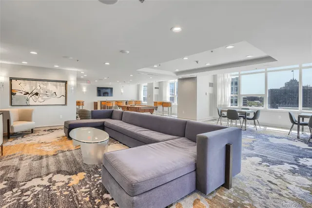 a living room with furniture and a view of kitchen