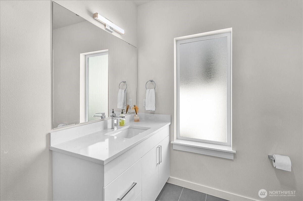 8922 Northeast 173rd Place, Unit A Bothell, WA 98011 - Photo 17 of 26 a bathroom with a sink a toilet and a mirror