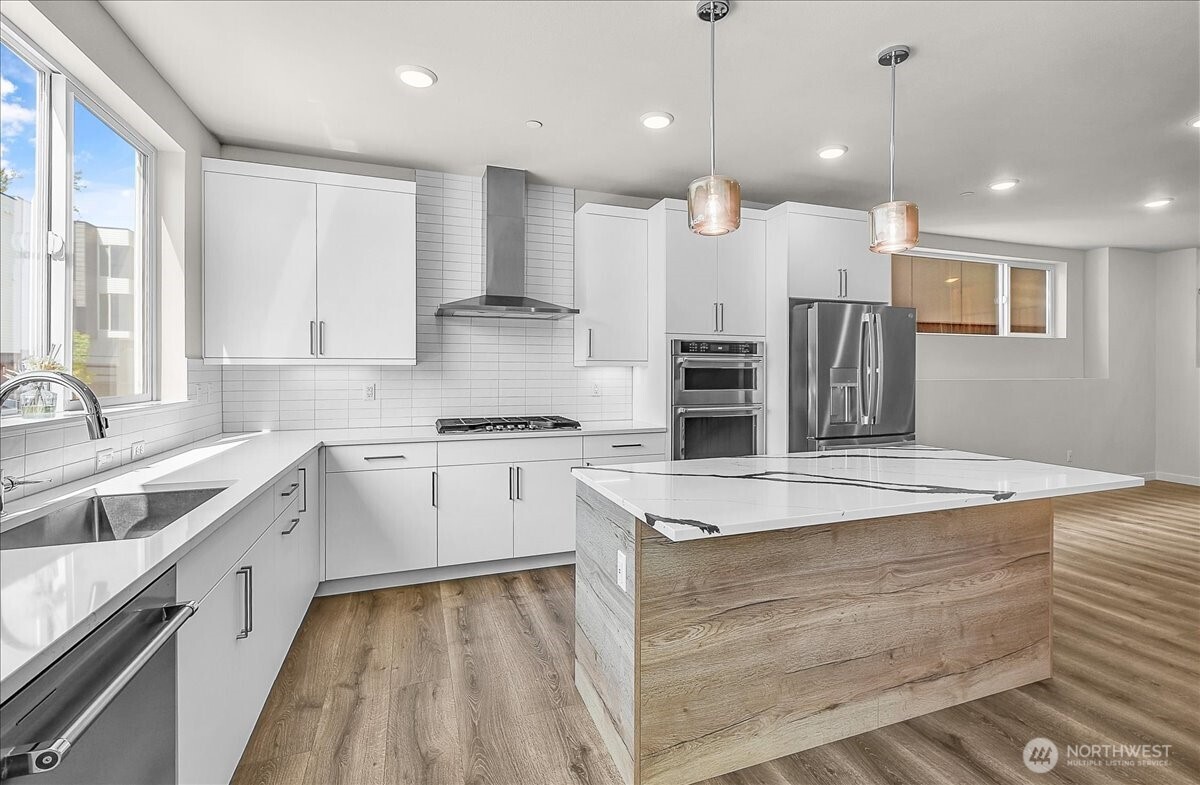 8922 Northeast 173rd Place, Unit A Bothell, WA 98011 - Photo 2 of 26 a large kitchen with stainless steel appliances kitchen island granite countertop a sink a stove and a granite counter tops