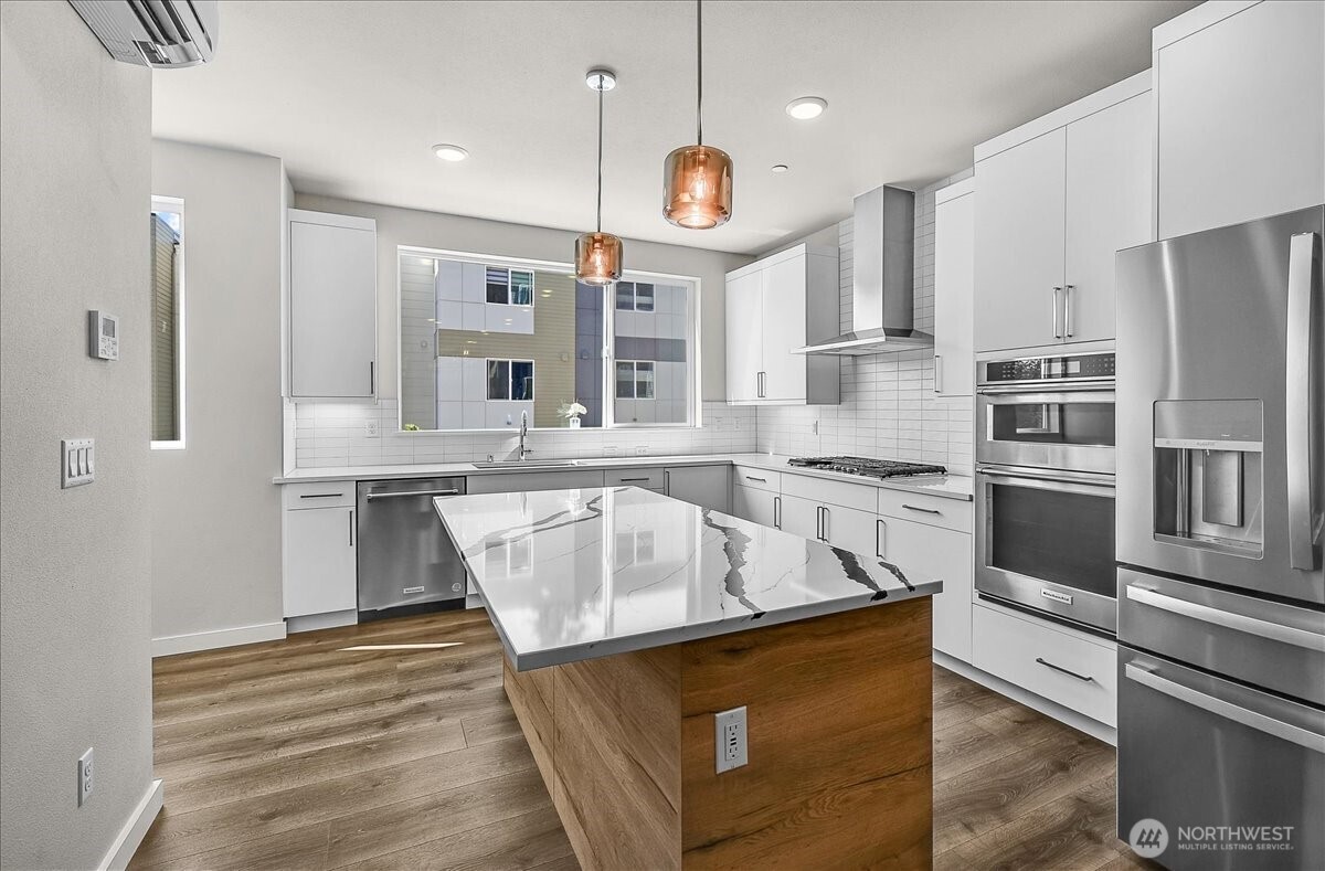 8922 Northeast 173rd Place, Unit A Bothell, WA 98011 - Photo 3 of 26 a kitchen with stainless steel appliances granite countertop a sink a stove and a refrigerator