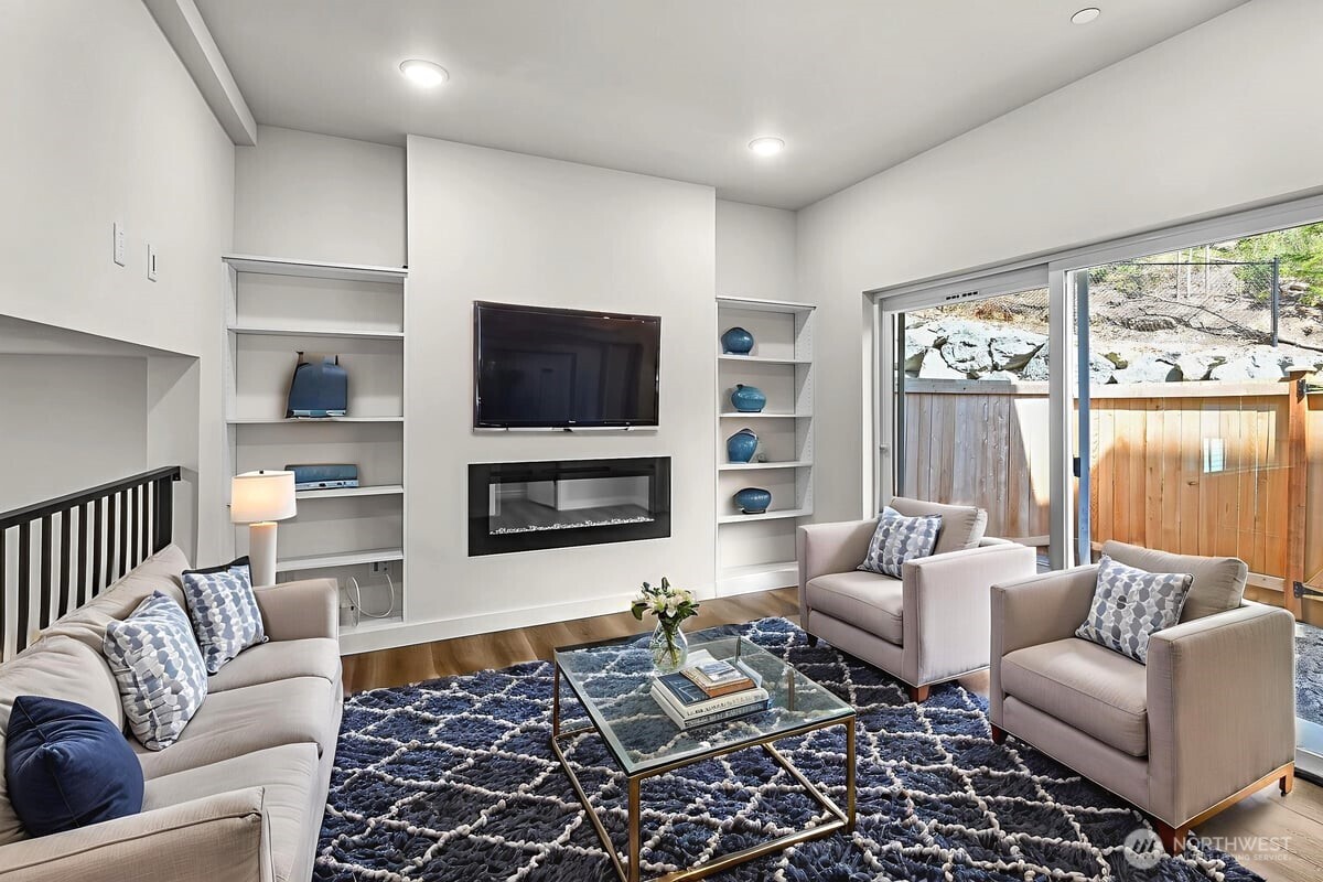 8922 Northeast 173rd Place, Unit A Bothell, WA 98011 - Photo 6 of 26 a living room with furniture a flat screen tv and a fireplace