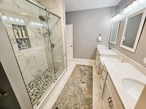 a bathroom with a sink and mirror with bathtub