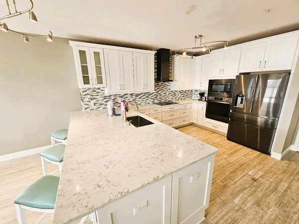 a kitchen with granite countertop a sink a stove and refrigerator