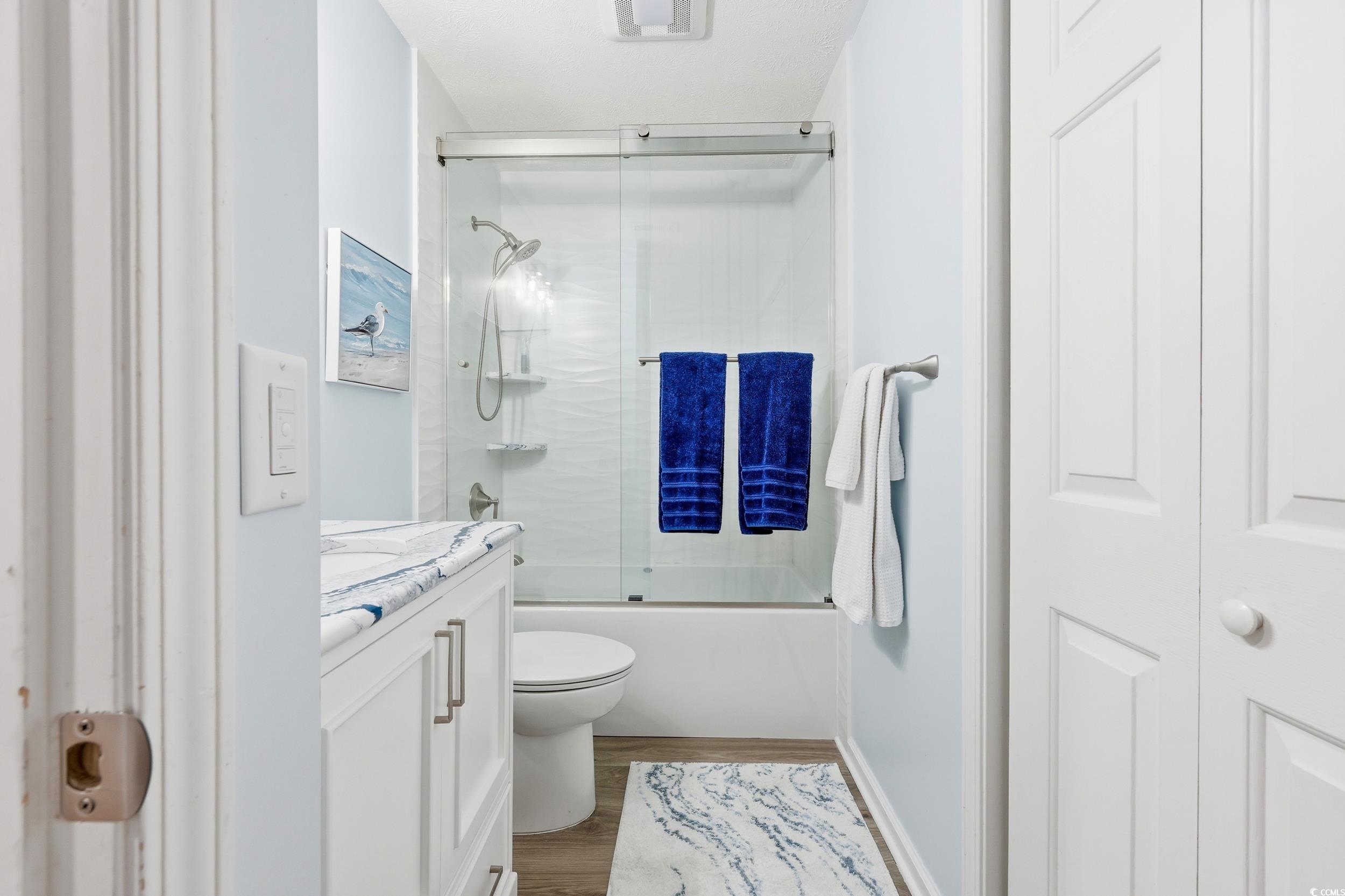 448 Pinehurst Lane, Unit 16F Pawleys Island, SC 29585 - Photo 3 of 31 Bathroom featuring vanity, shower / bath combination with glass door, and wood finished floors