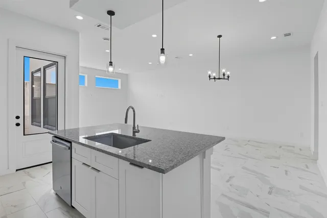 a kitchen with stainless steel appliances granite countertop a sink a refrigerator and a granite counter tops