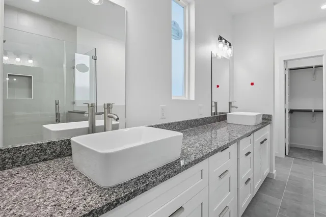 a bathroom with a granite countertop sink and a mirror