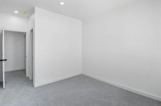 a view of empty room with windows and wardrobe