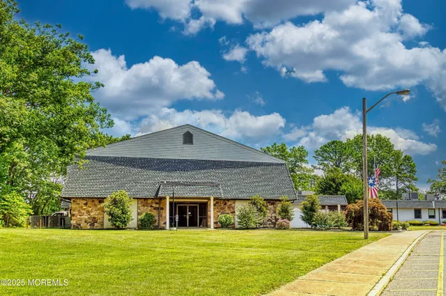 a view of a swimming pool with lawn chairs under an umbrella