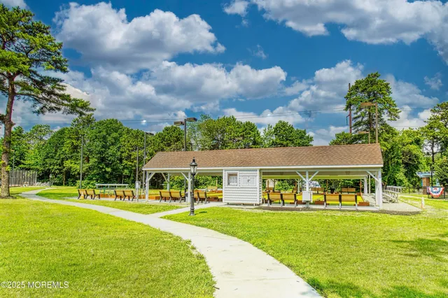a front view of house and yard with beautiful flowers and green space