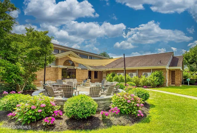 a view of a garden with a bench in front of the house