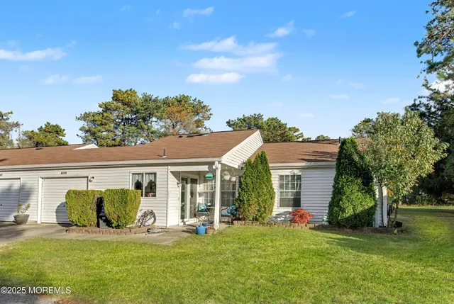 a front view of a house with a garden and trees