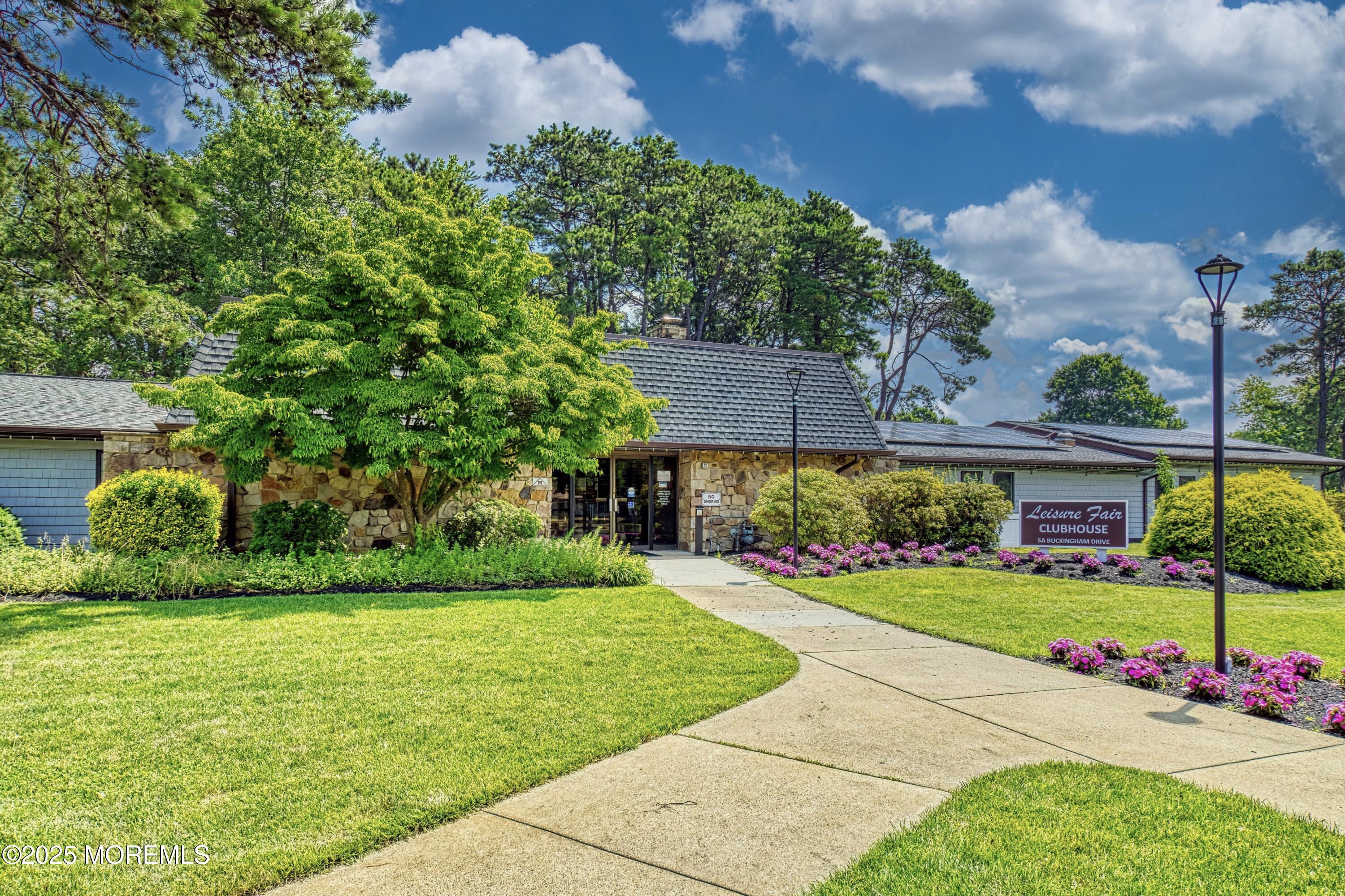 567 A Mayfair Road Manchester Township, NJ 08759 - Photo 31 of 46 a view of a garden with a bench in front of the house