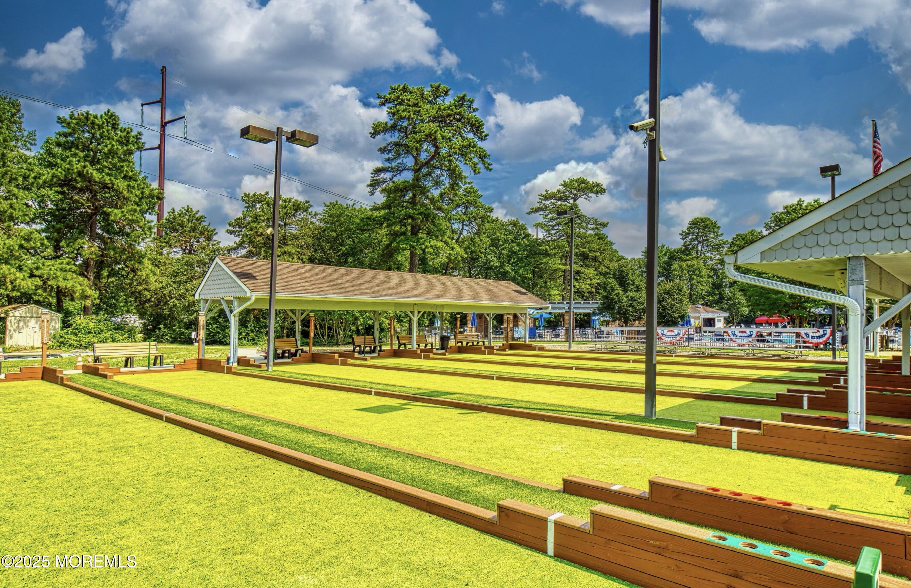 567 A Mayfair Road Manchester Township, NJ 08759 - Photo 40 of 46 a view of a swimming pool with a lawn chairs under an umbrella