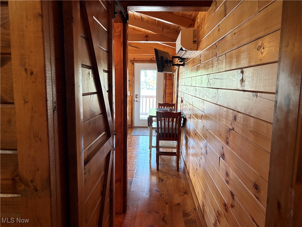 5919 Lake Road West, Unit 7 Ashtabula, OH 44004 - Photo 17 of 29 Corridor with wood walls, dark wood-style flooring, an AC wall unit, and wooden ceiling