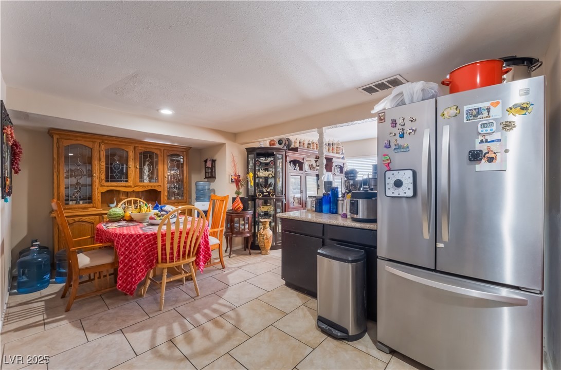 1908 Ardmore Street Las Vegas, NV 89104 - Photo 15 of 29 Kitchen with freestanding refrigerator, a textured ceiling, light countertops, light tile patterned floors, and recessed lighting