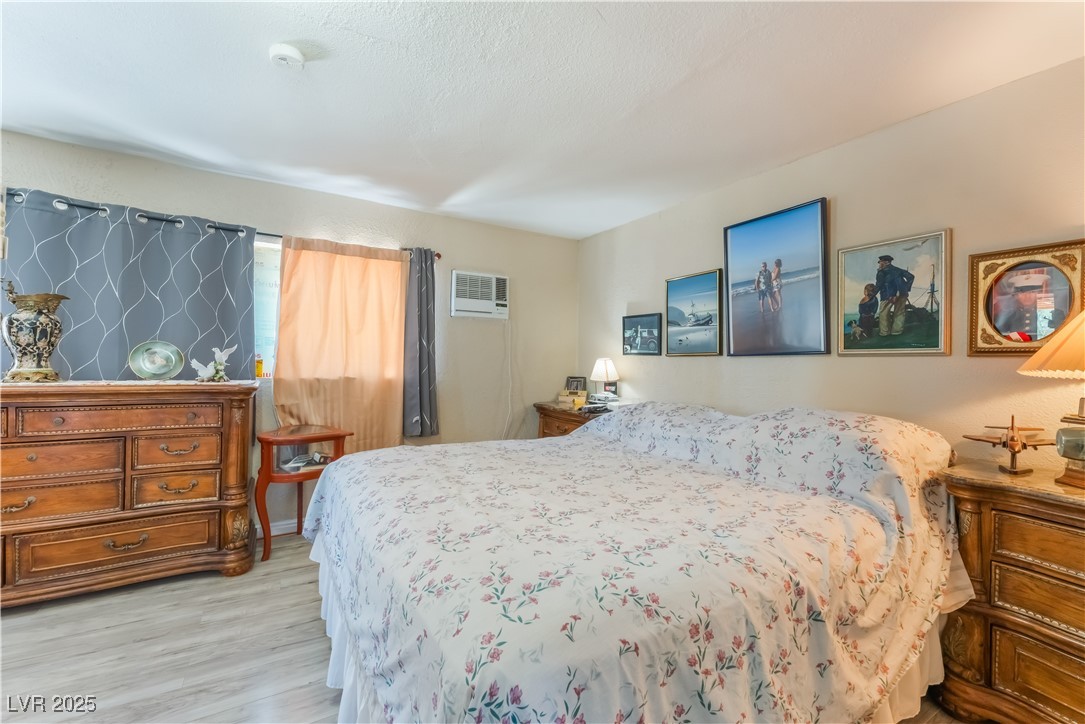 1908 Ardmore Street Las Vegas, NV 89104 - Photo 17 of 29 Bedroom featuring light wood-type flooring and a wall unit AC