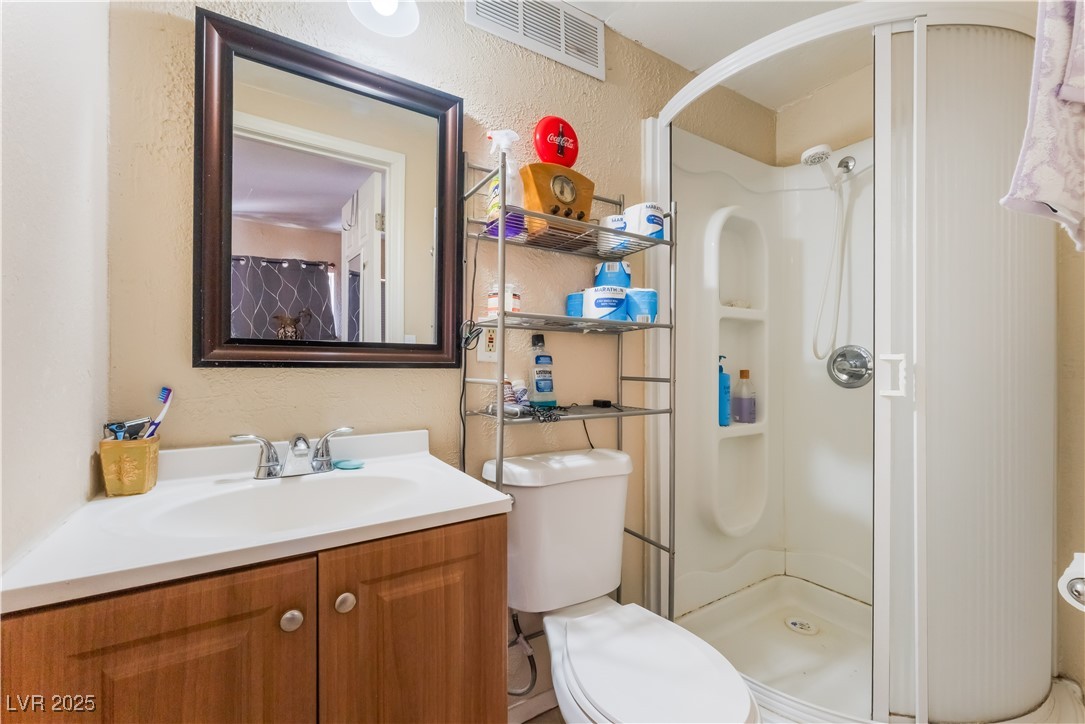 1908 Ardmore Street Las Vegas, NV 89104 - Photo 20 of 29 Full bathroom featuring a textured wall, vanity, and a shower stall