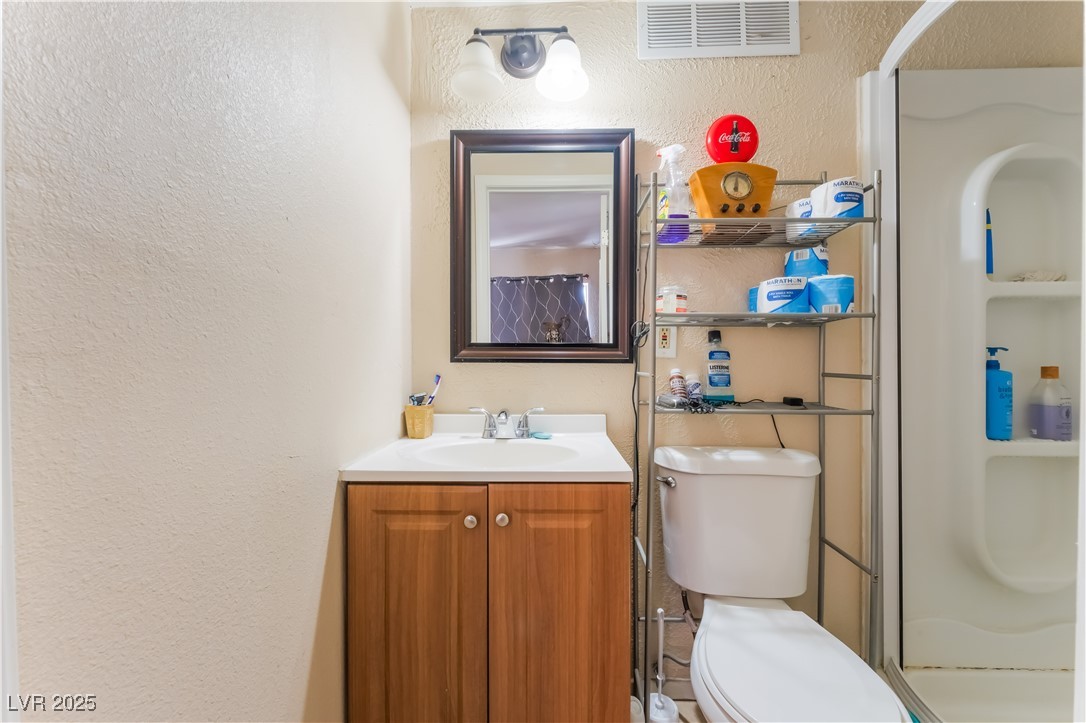 1908 Ardmore Street Las Vegas, NV 89104 - Photo 21 of 29 Bathroom featuring a textured wall, vanity, and a shower