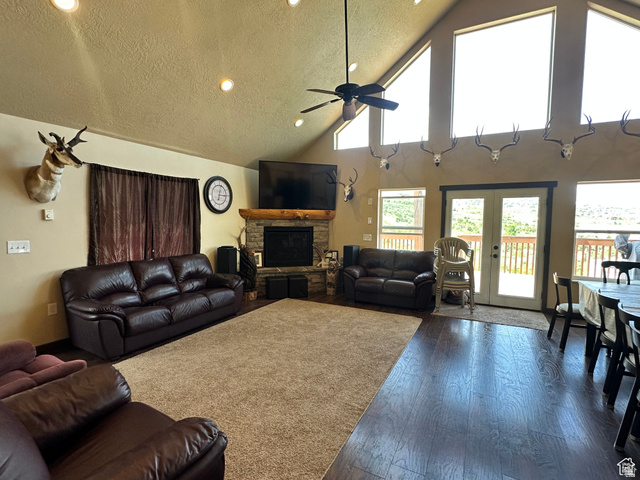 12 Crook Street Fish Haven, ID 83287 - Photo 16 of 35 Living room featuring dark wood-style floors, a ceiling fan, recessed lighting, a fireplace, and a high textured ceiling