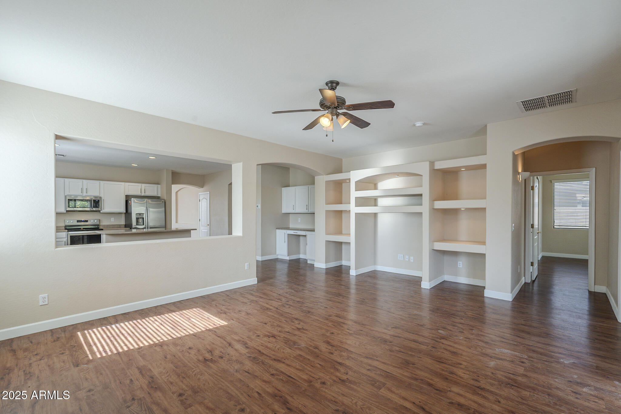 15902 West Hearn Road Surprise, AZ 85379 - Photo 12 of 73 a view of a livingroom with wooden floor and a ceiling fan