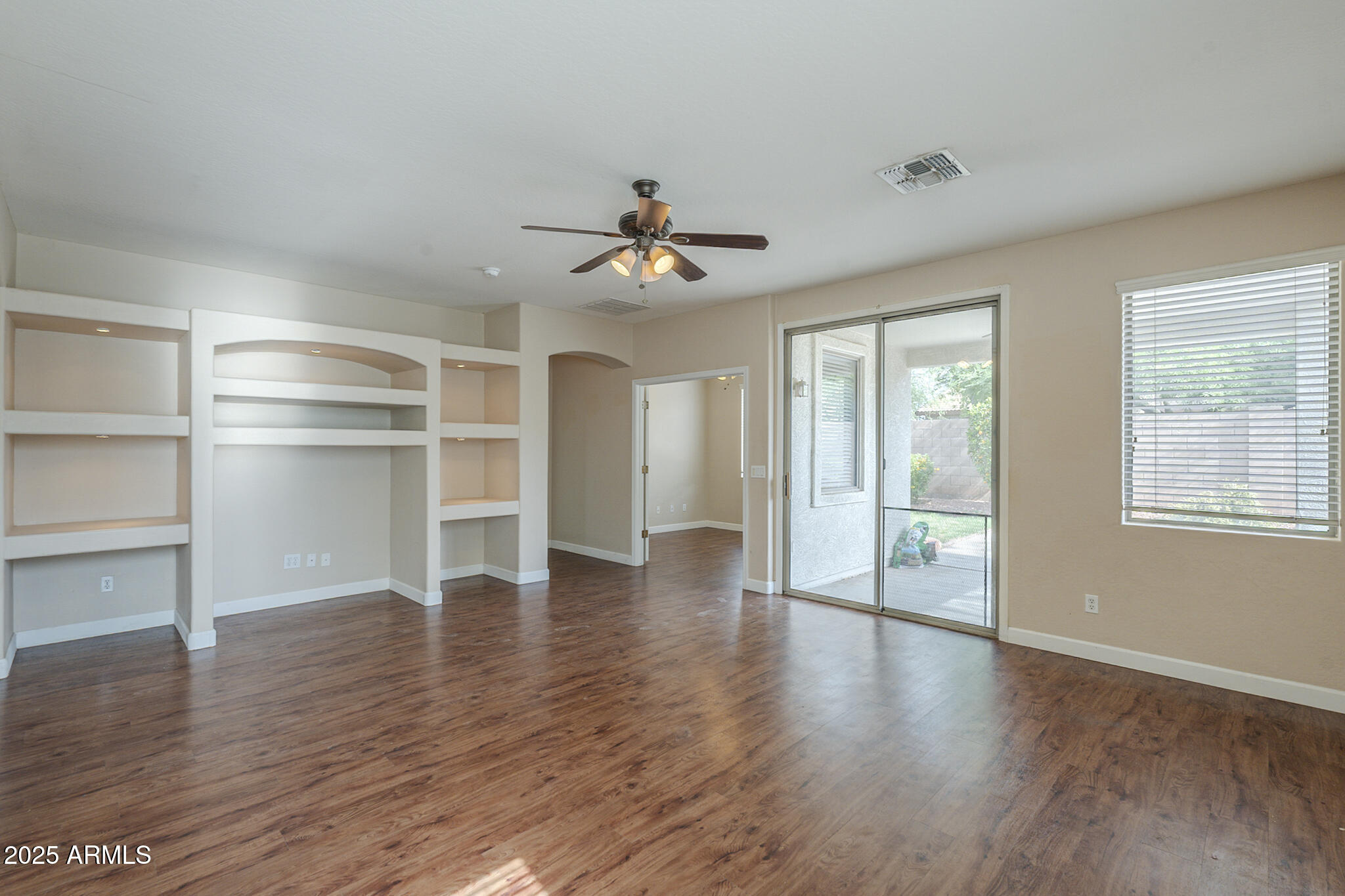 15902 West Hearn Road Surprise, AZ 85379 - Photo 13 of 73 a view of an empty room with a window and wooden floor