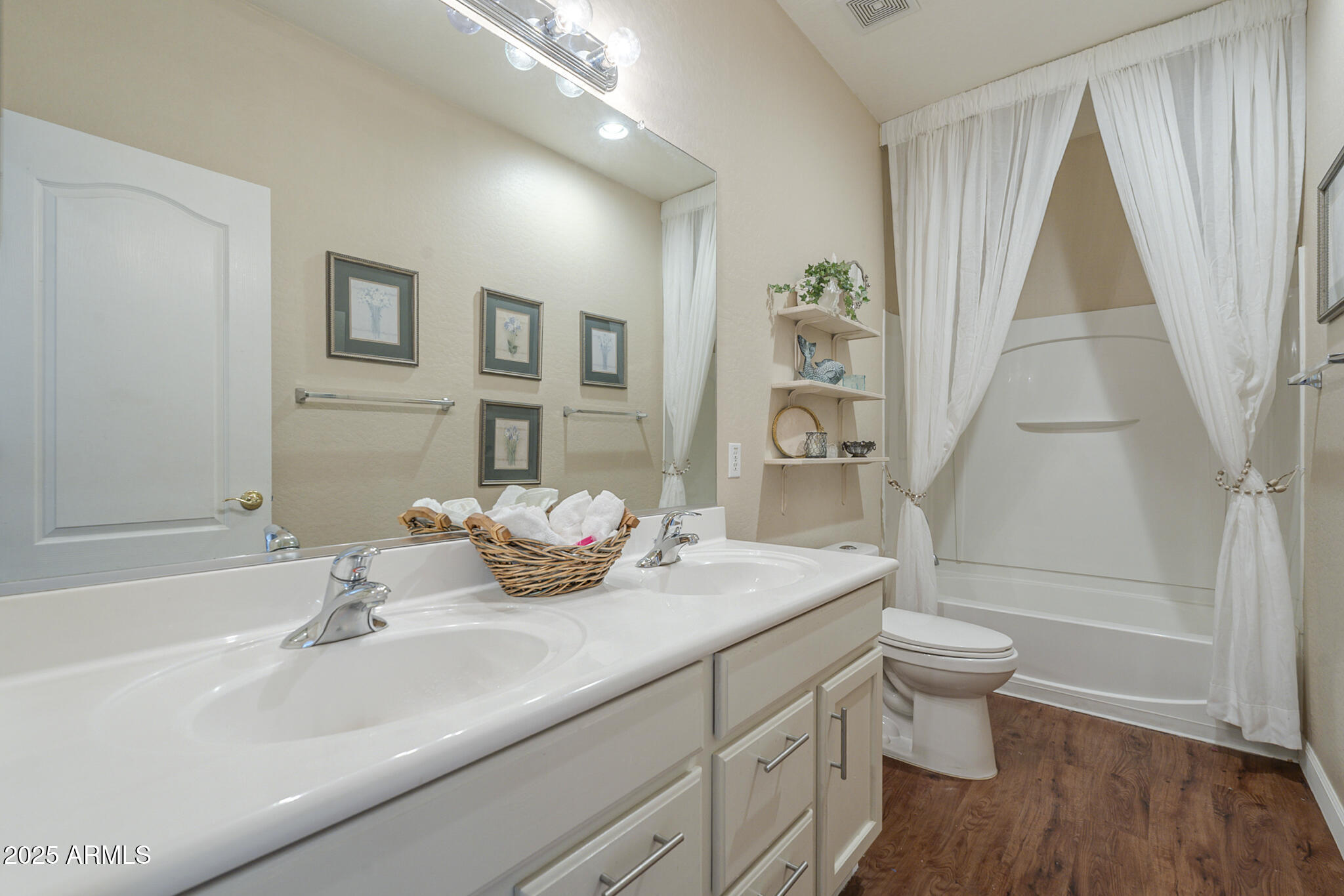 15902 West Hearn Road Surprise, AZ 85379 - Photo 18 of 73 a bathroom with a sink a toilet and a large mirror