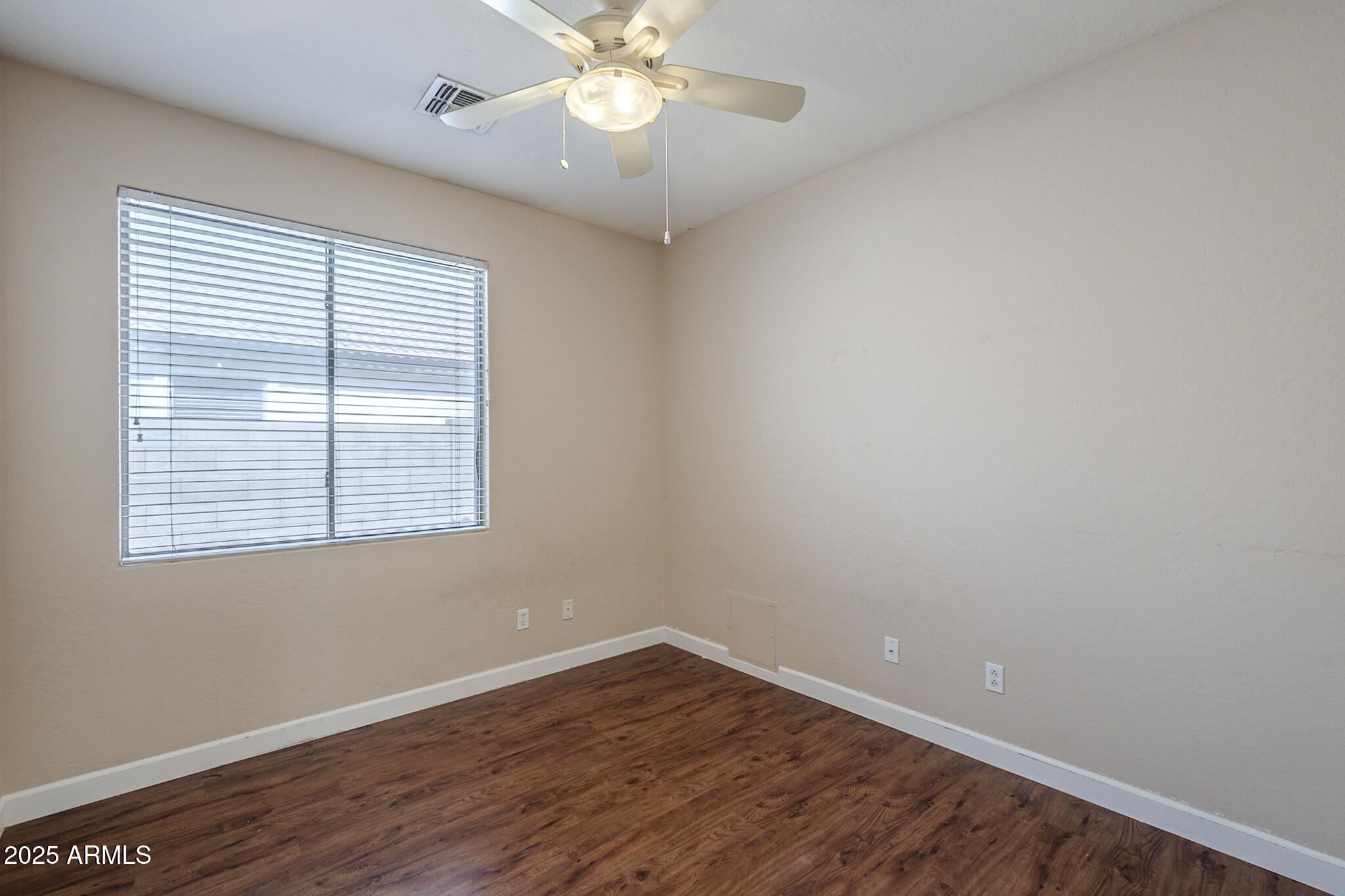 15902 West Hearn Road Surprise, AZ 85379 - Photo 19 of 73 an empty room with wooden floor and windows