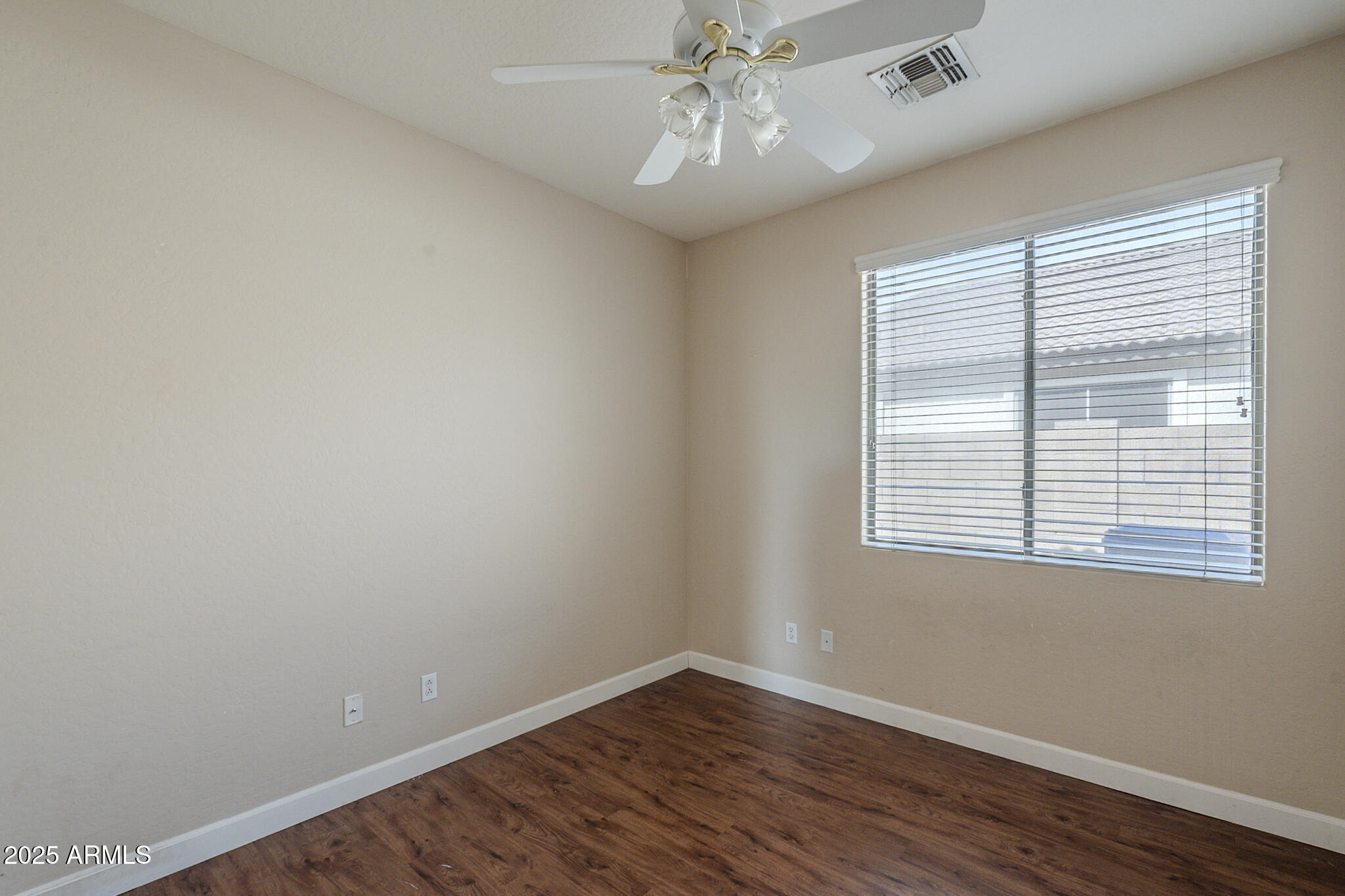 15902 West Hearn Road Surprise, AZ 85379 - Photo 20 of 73 a view of an empty room with wooden floor and a window