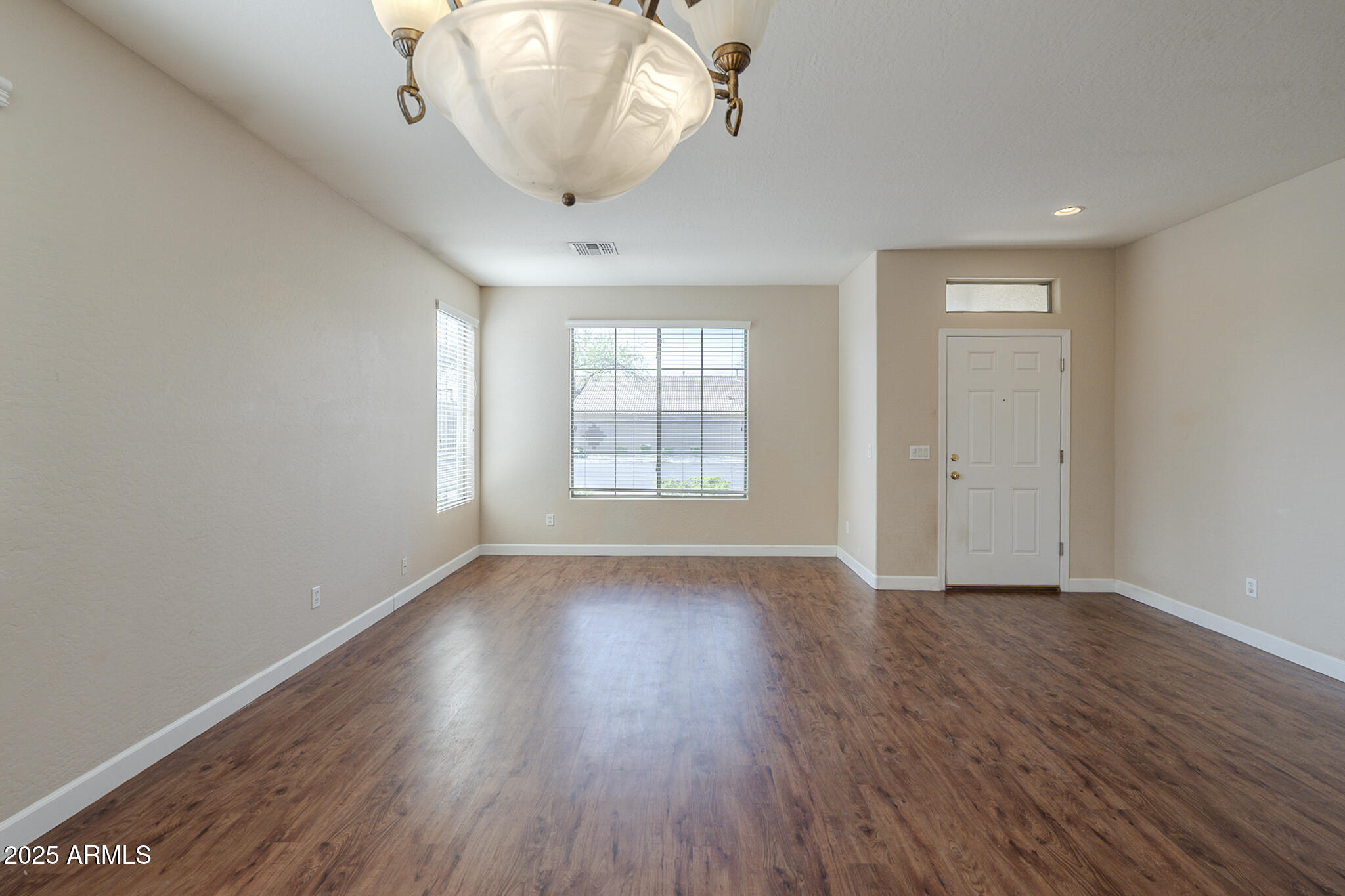 15902 West Hearn Road Surprise, AZ 85379 - Photo 30 of 73 an empty room with wooden floor and windows
