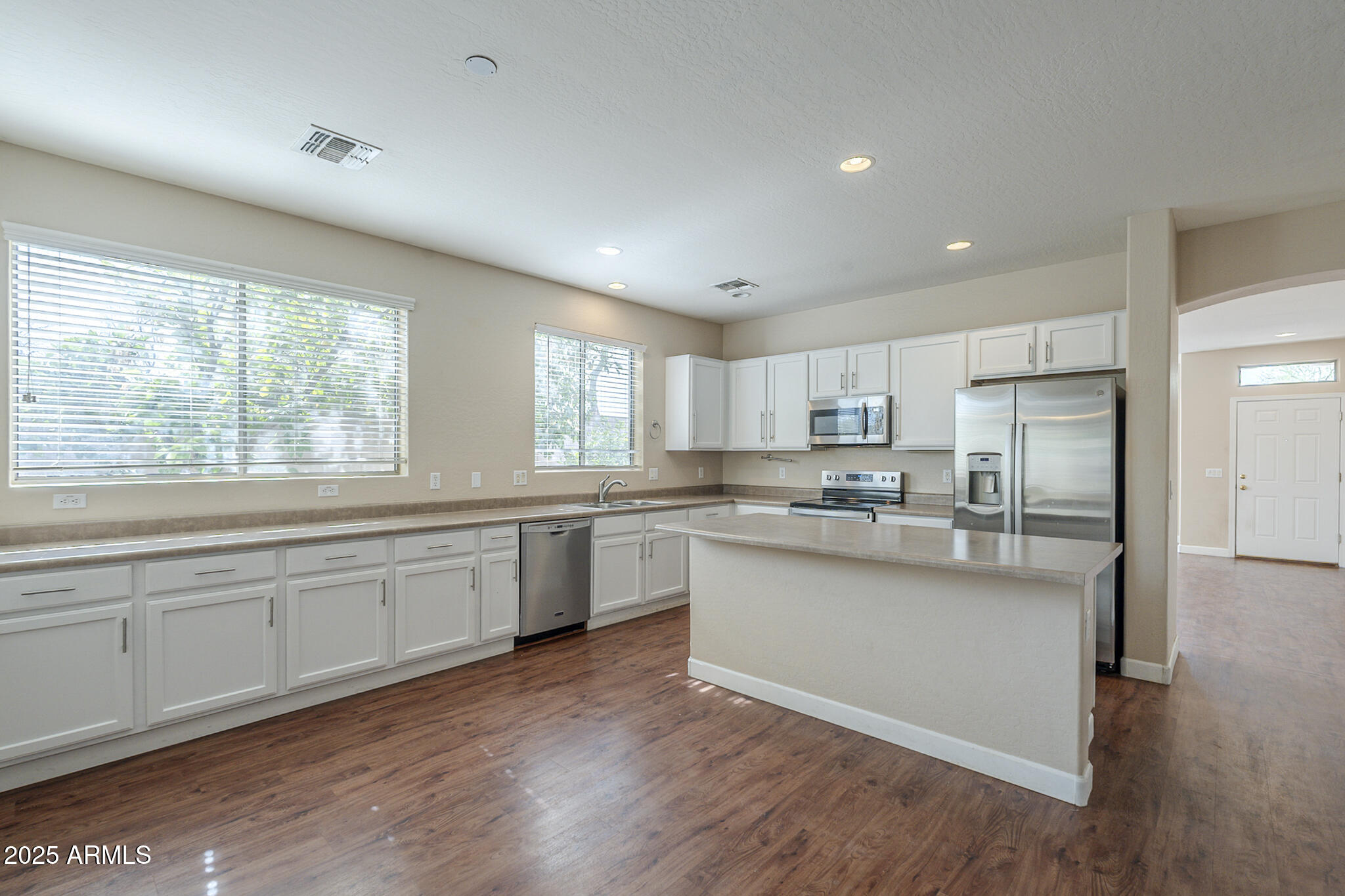 15902 West Hearn Road Surprise, AZ 85379 - Photo 34 of 73 a large kitchen with cabinets wooden floor and stainless steel appliances