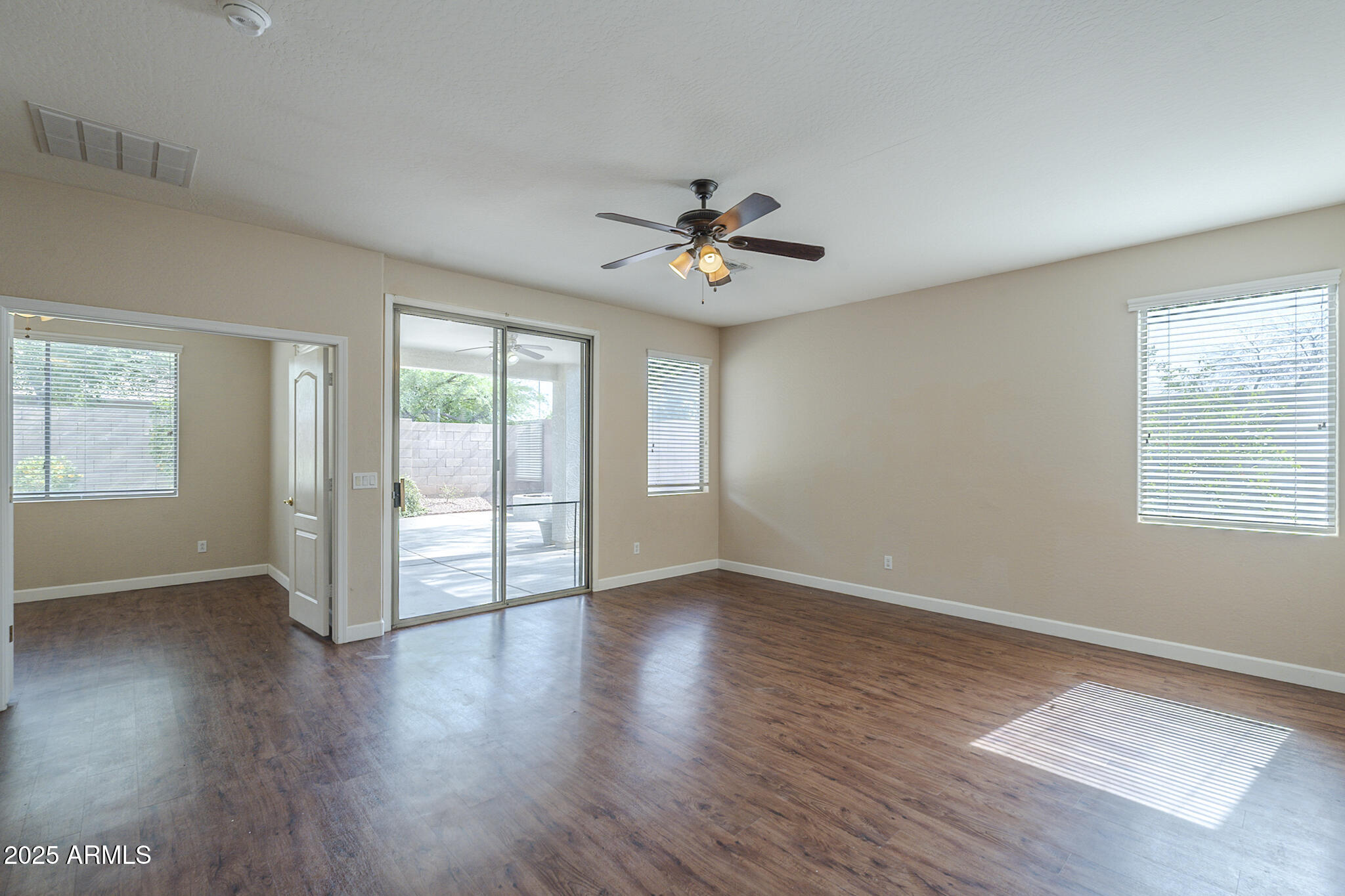 15902 West Hearn Road Surprise, AZ 85379 - Photo 40 of 73 an empty room with wooden floor and windows