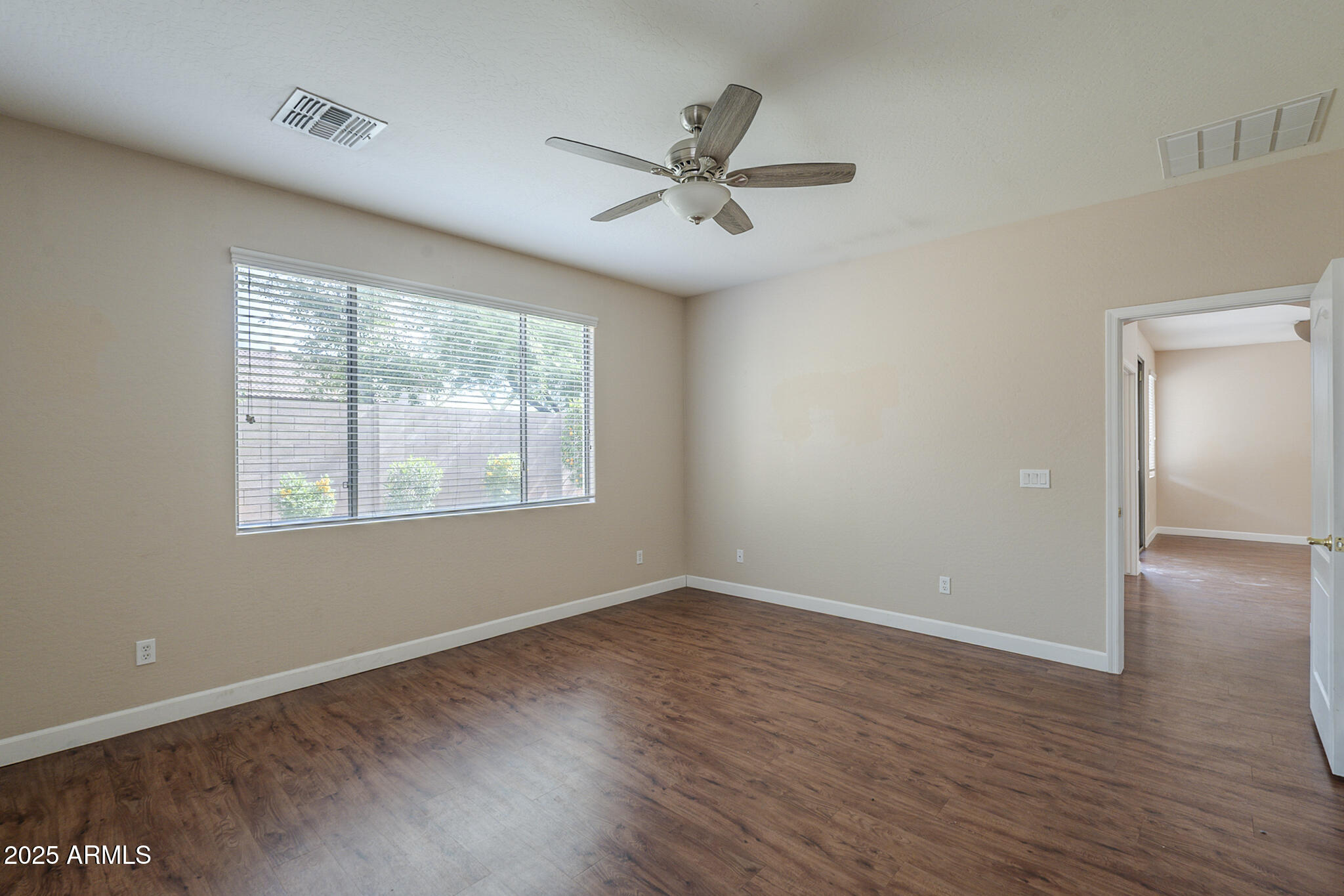 15902 West Hearn Road Surprise, AZ 85379 - Photo 45 of 73 an empty room with wooden floor fan and windows