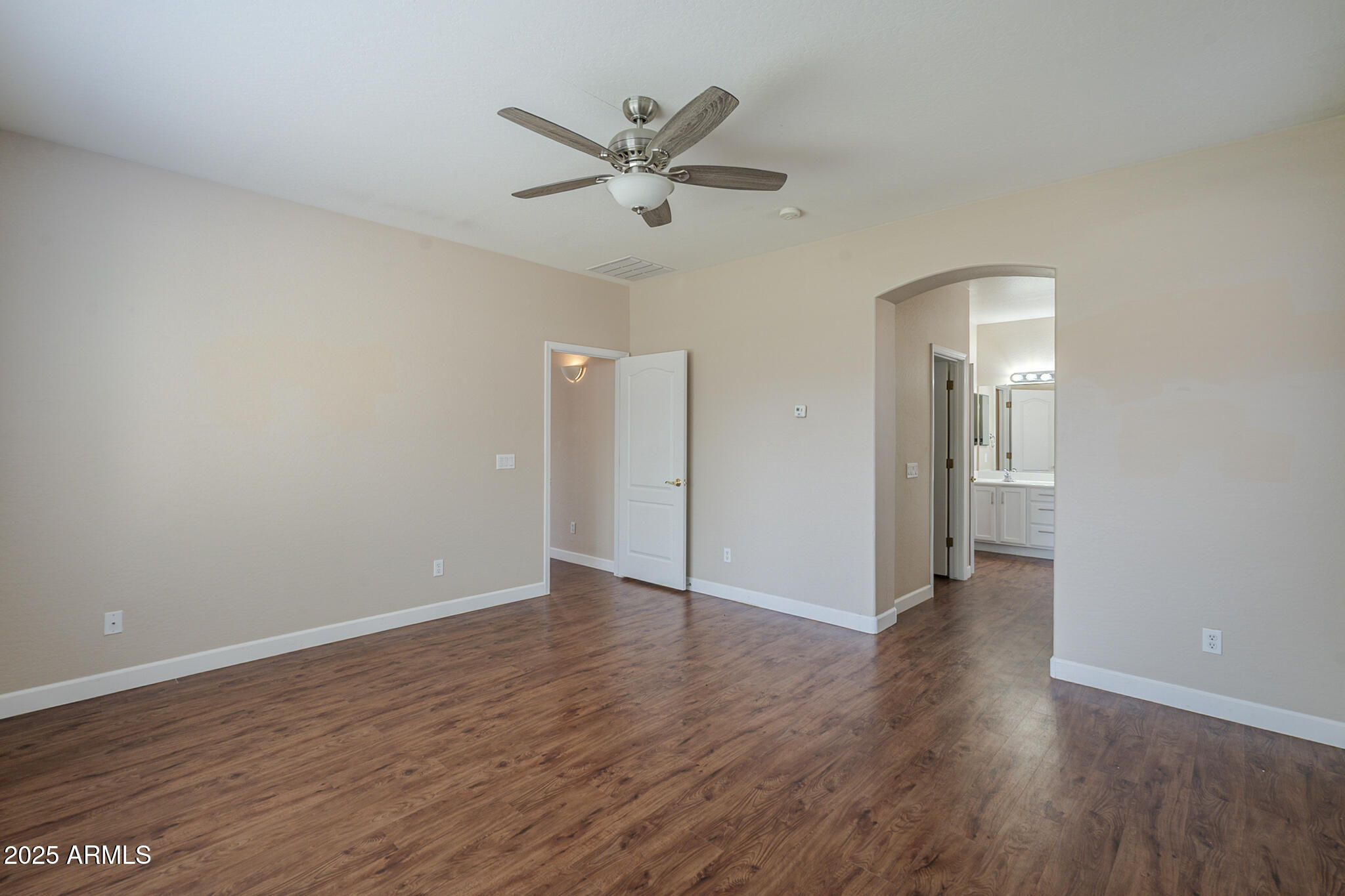 15902 West Hearn Road Surprise, AZ 85379 - Photo 46 of 73 an empty room with wooden floor and a ceiling fan