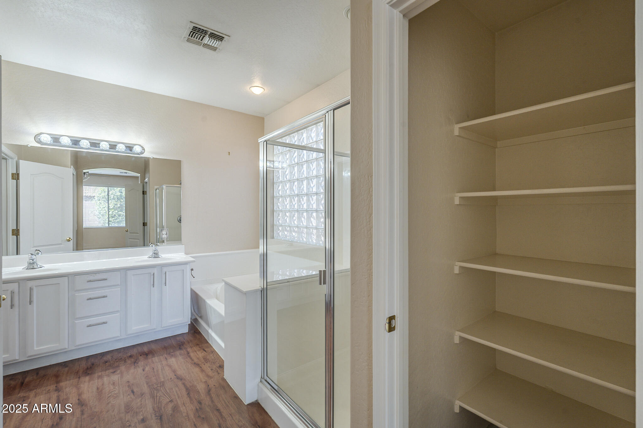 15902 West Hearn Road Surprise, AZ 85379 - Photo 48 of 73 a bathroom with a double vanity sink a mirror and a bathtub
